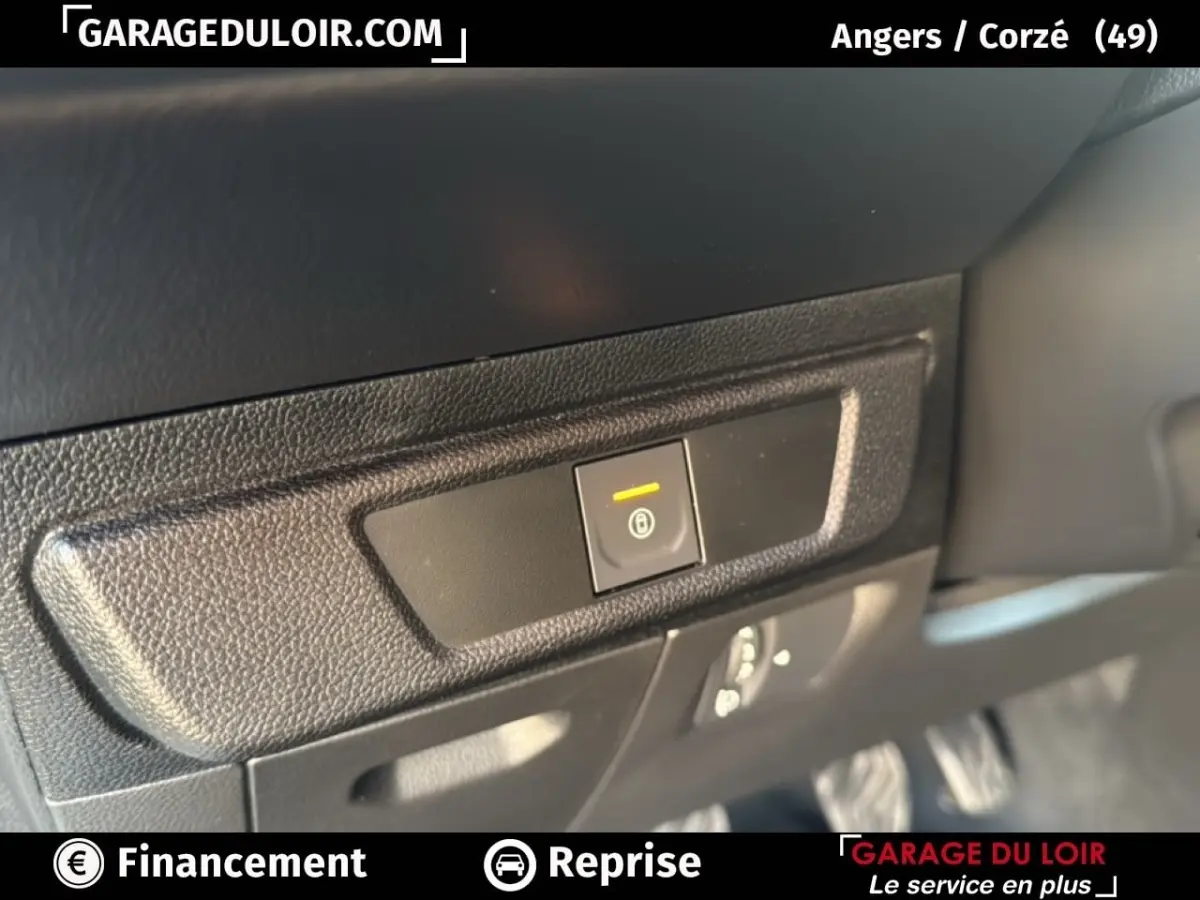 Gros plan sur le bouton de frein à main électronique dans l'habitacle noir du Dacia Sandero blanc 2025.