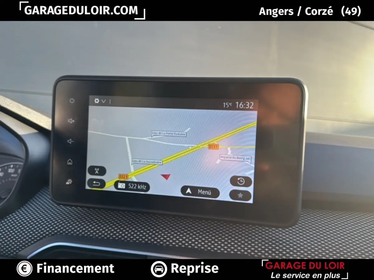 Écran tactile central affichant la navigation GPS dans un Dacia Sandero blanc, vue intérieure du tableau de bord.