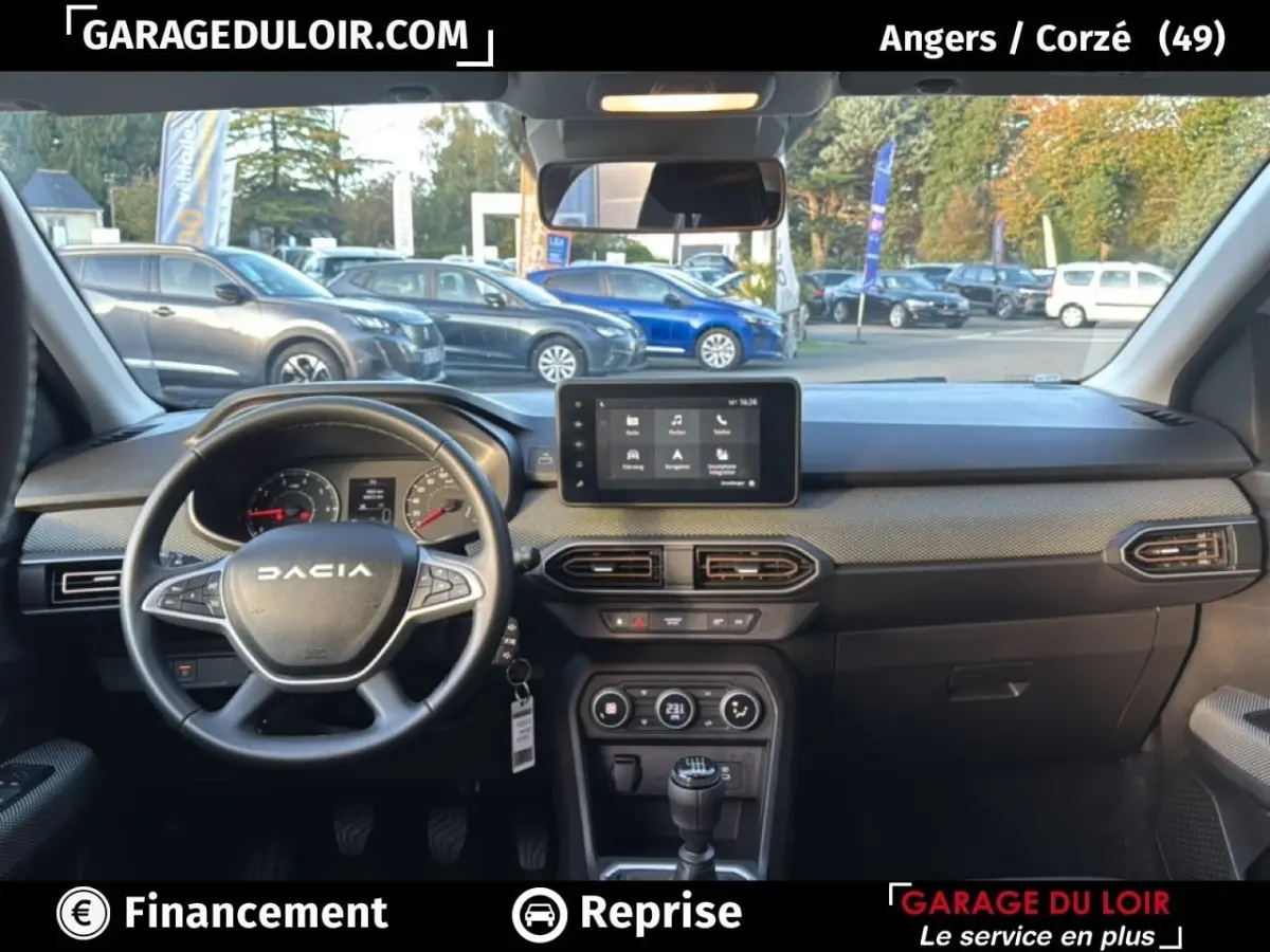 Vue intérieure du tableau de bord de la Dacia Sandero Expression TCe 90 2025, volant à gauche et écran tactile central.