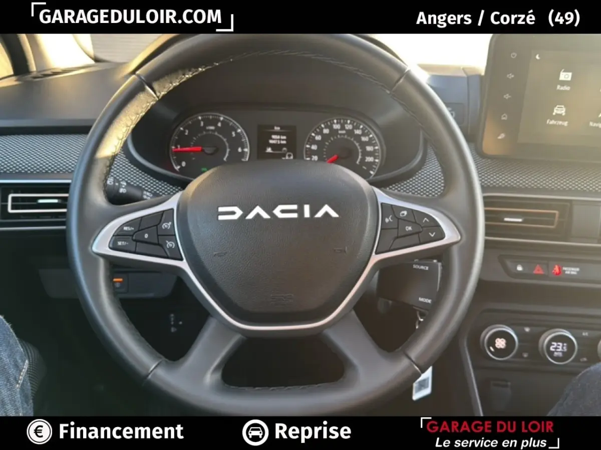 Vue intérieure centrée sur le volant noir du Dacia Sandero Expression TCe 90 2025 avec tableau de bord et écran tactile.