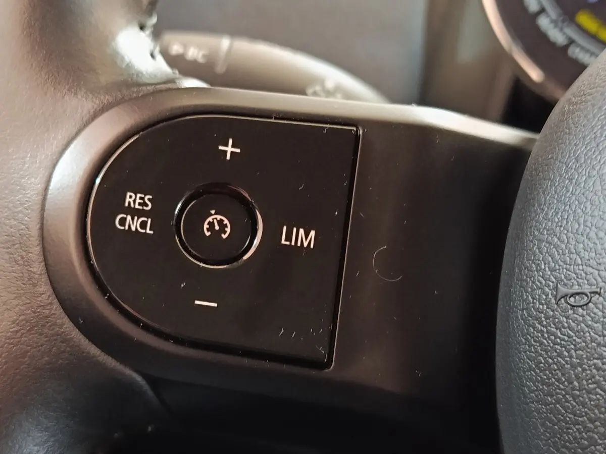 Gros plan sur les commandes du régulateur de vitesse au volant cuir noir du MINI Countryman Cooper SE 2023.