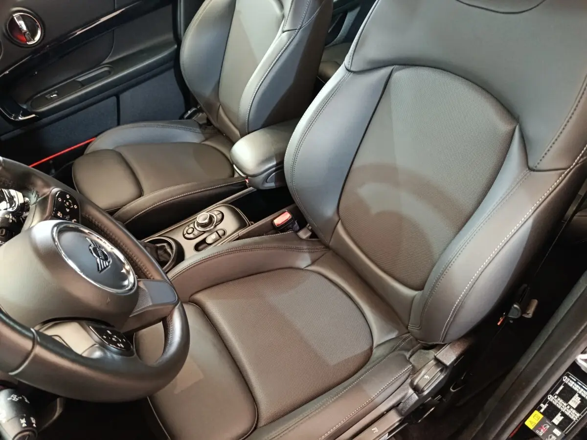 Vue intérieure rapprochée côté conducteur du MINI Countryman Cooper SE avec sièges cuir noirs et volant multifonctions.