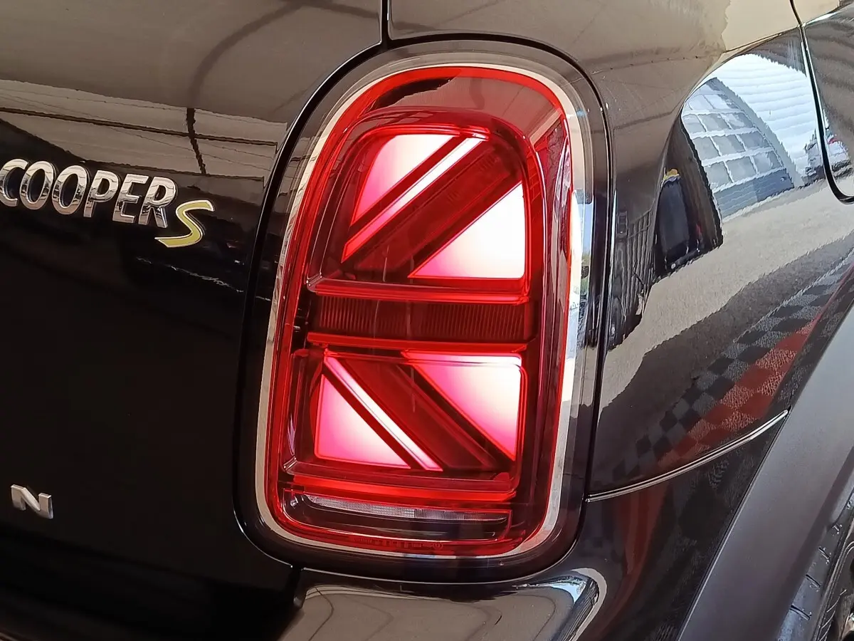 Gros plan sur le feu arrière droit rouge et le logo Cooper S sur la carrosserie noire du MINI Countryman 2023.