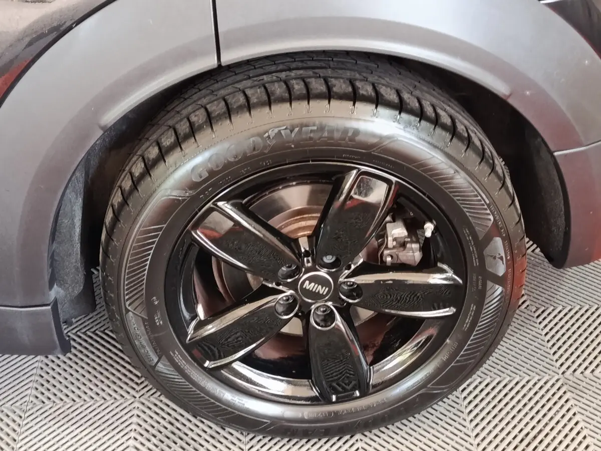 Gros plan sur la roue avant gauche noire brillante d’un MINI Countryman Cooper SE 2023 avec pneu Goodyear.