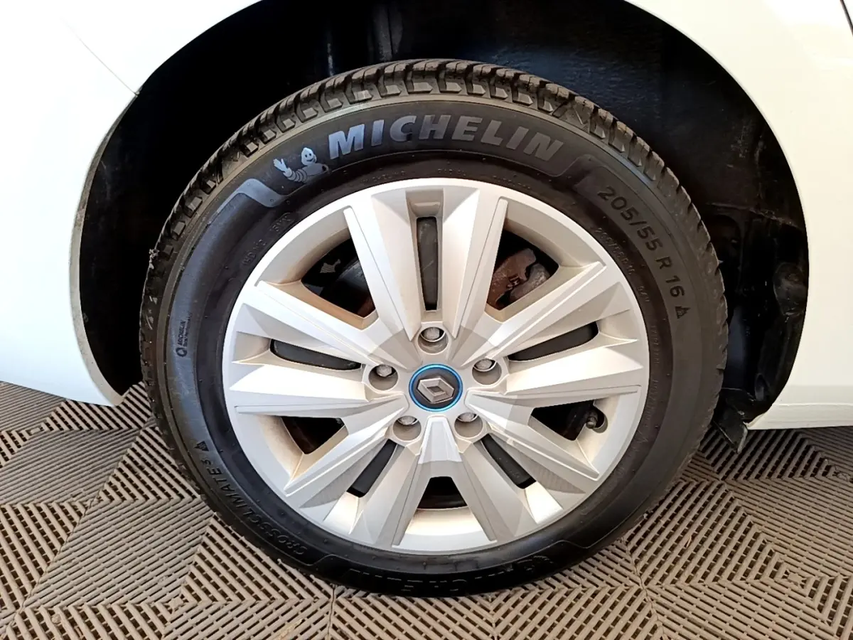 Gros plan sur la roue avant droite blanche d'une Renault Mégane Business E-Tech hybride rechargeable avec jante argentée.