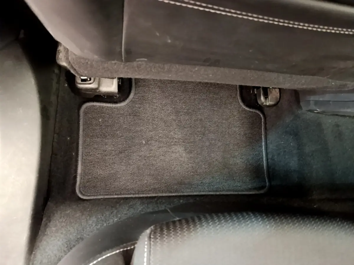 Vue intérieure du tapis de sol noir côté passager avant de la Renault Mégane Business E-Tech hybride rechargeable blanche 2022.
