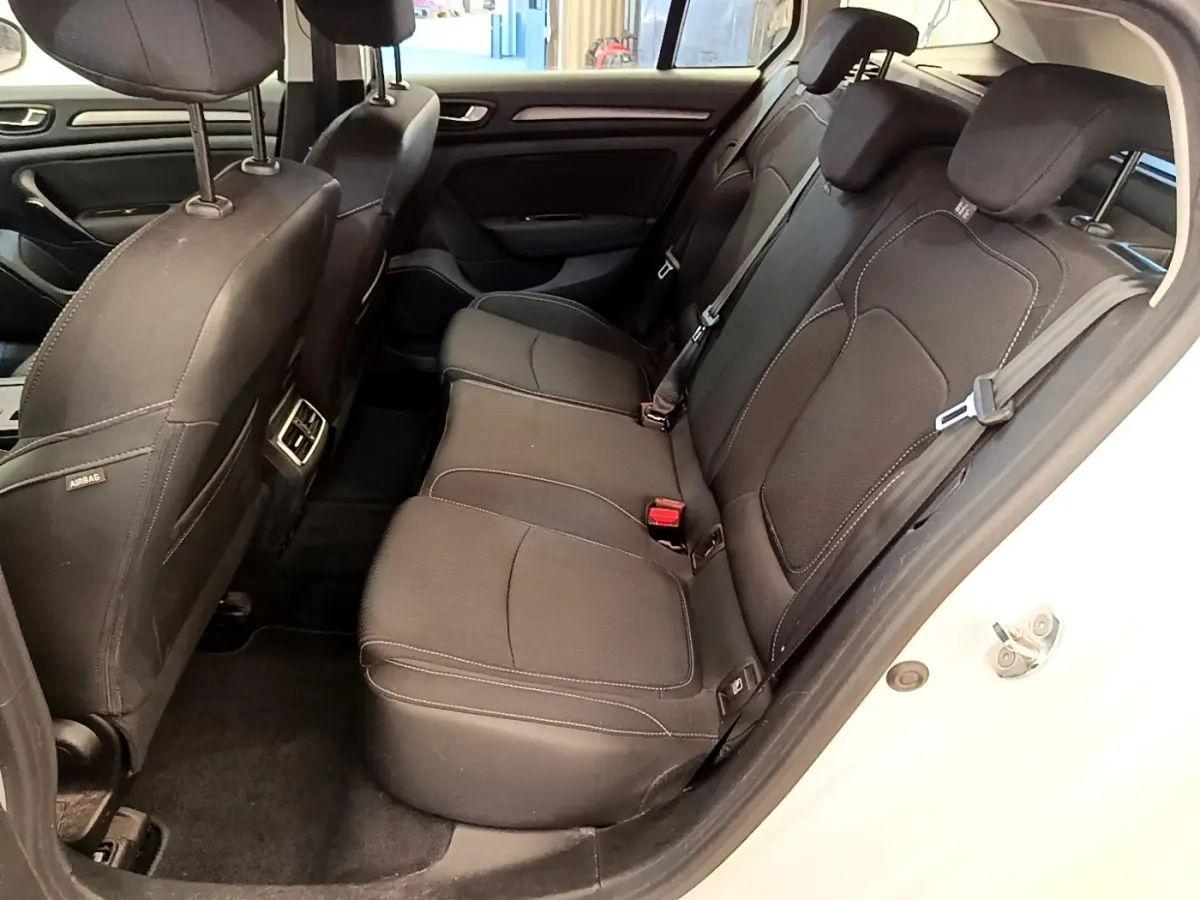 Vue intérieure côté droit sur la banquette arrière noire d'une Renault Mégane Business E-Tech hybride rechargeable blanche.