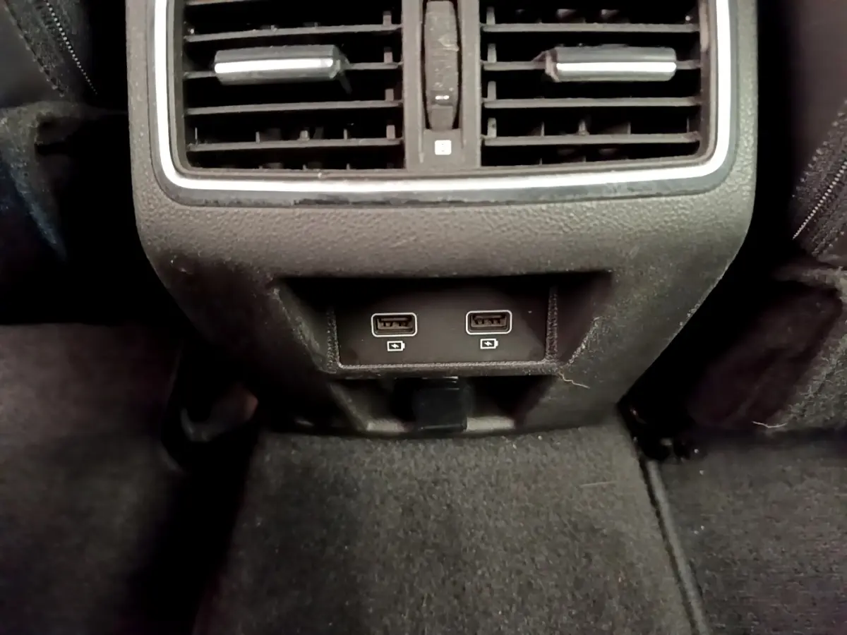Prise USB double et sortie d’aération arrière dans l’habitacle noir de la Renault Megane Business E-Tech hybride rechargeable.