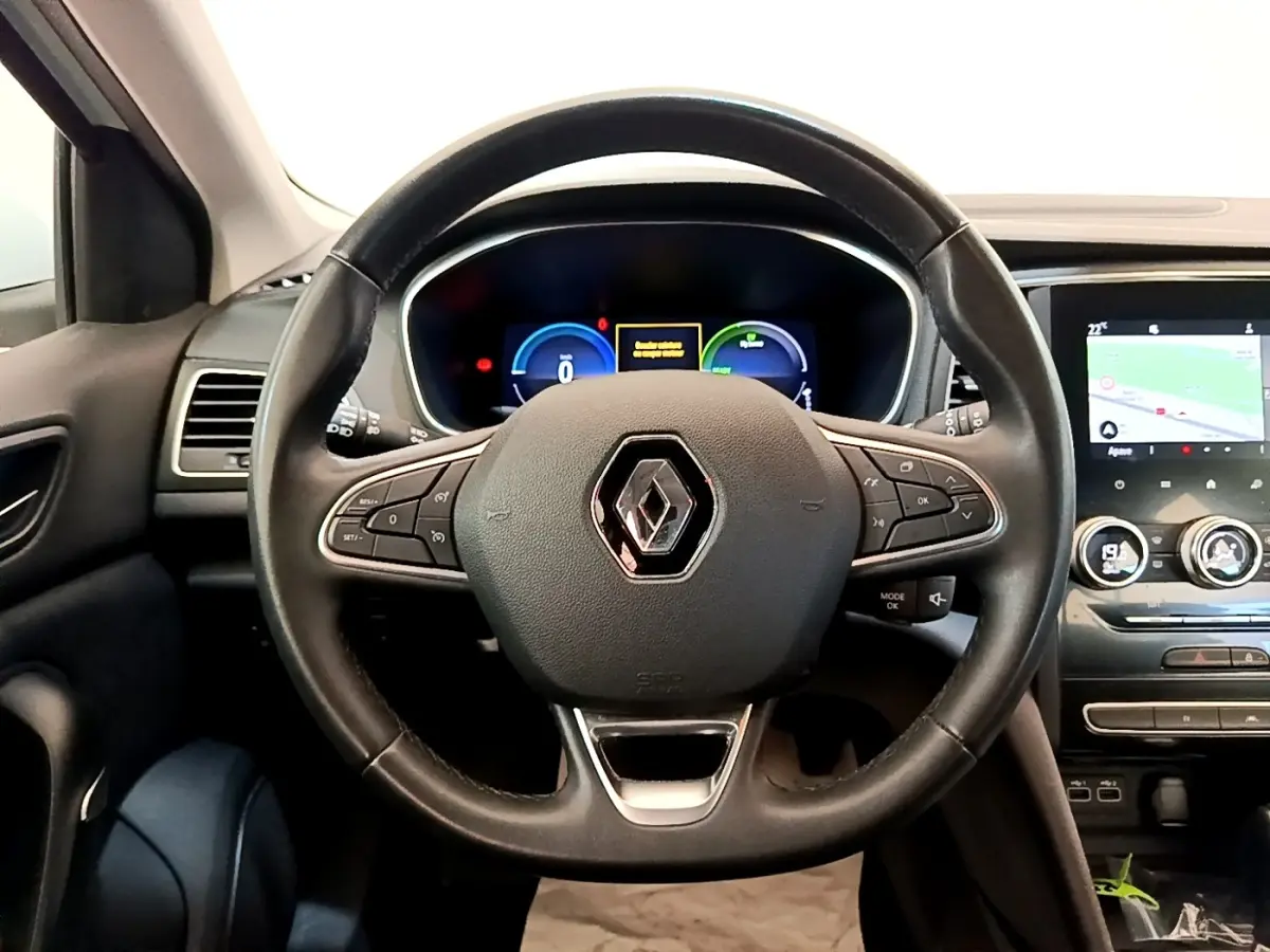Vue intérieure centrée sur le volant noir Renault Megane Business E-Tech 2022 avec tableau de bord digital et écran tactile.