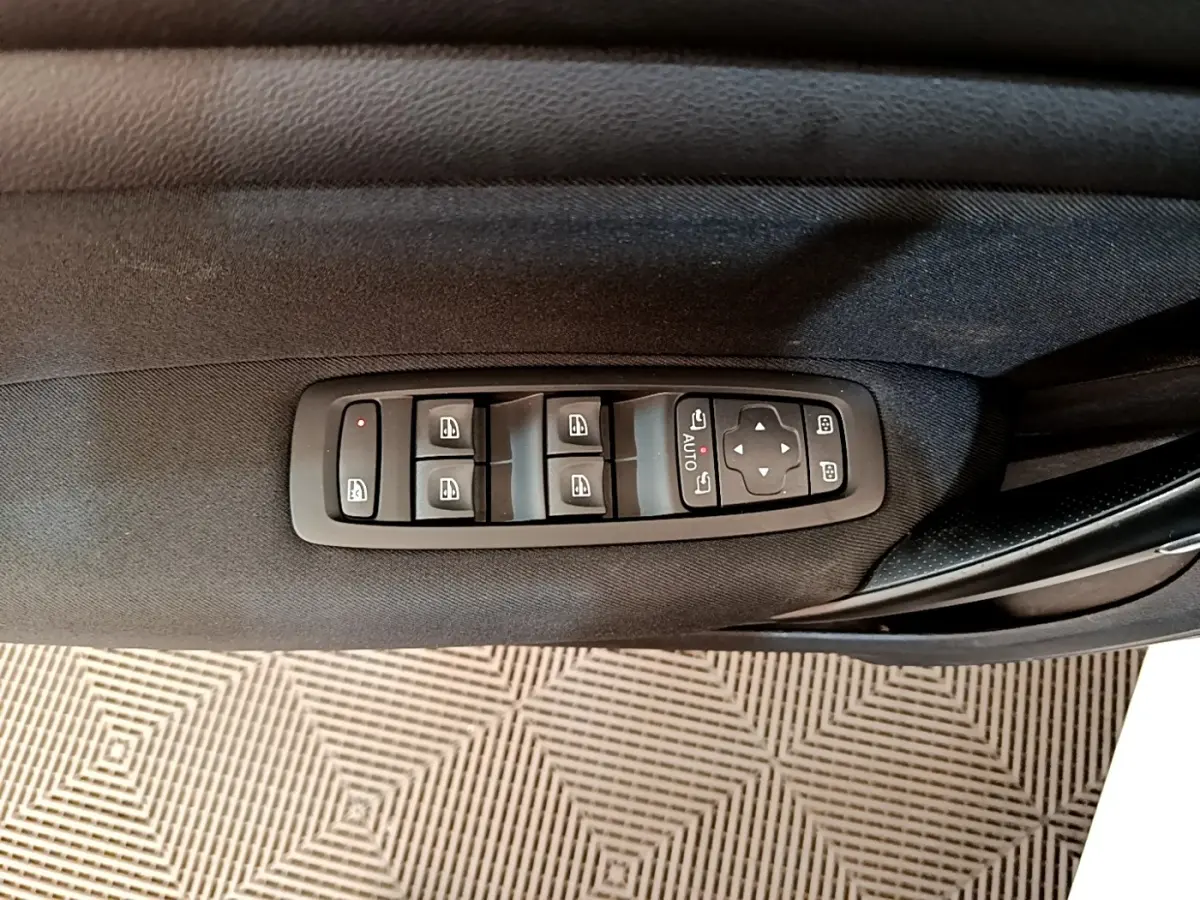 Commande des vitres et rétroviseurs sur la porte côté conducteur d’une Renault Mégane Business E-Tech blanche, vue intérieure.