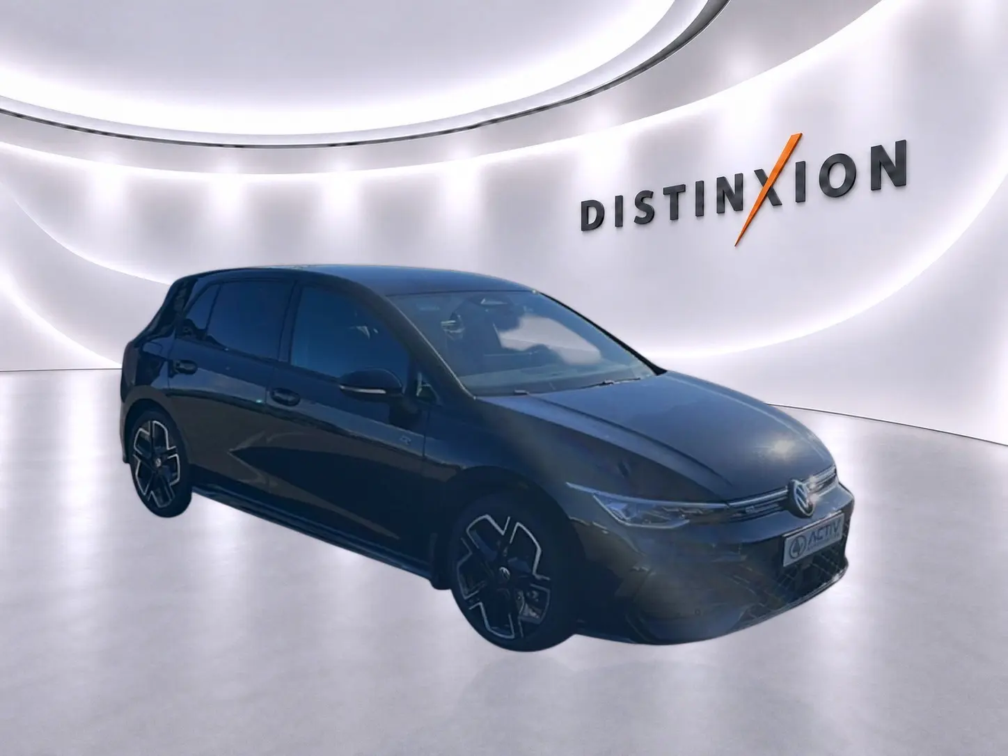 Volkswagen Golf noir vue 3/4 avant droit dans un showroom avec logo Distinxion en arrière-plan.