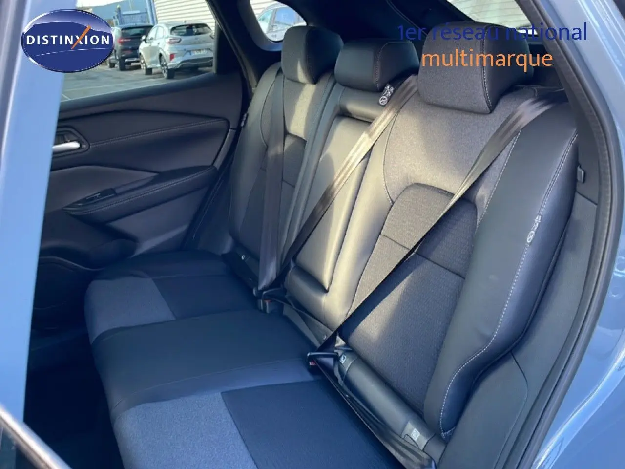 Vue intérieure montrant la banquette arrière en cuir et tissu noir du Nissan Qashqai 2025, porte arrière ouverte.