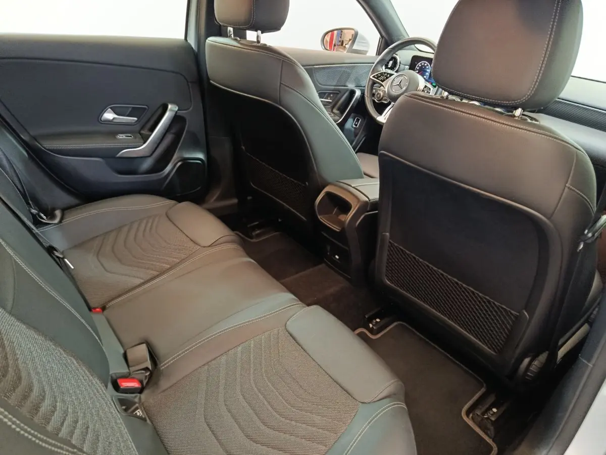 Vue intérieure arrière de la Mercedes Classe A 250 e Business Line 2023, sièges en cuir noir et détails modernes.