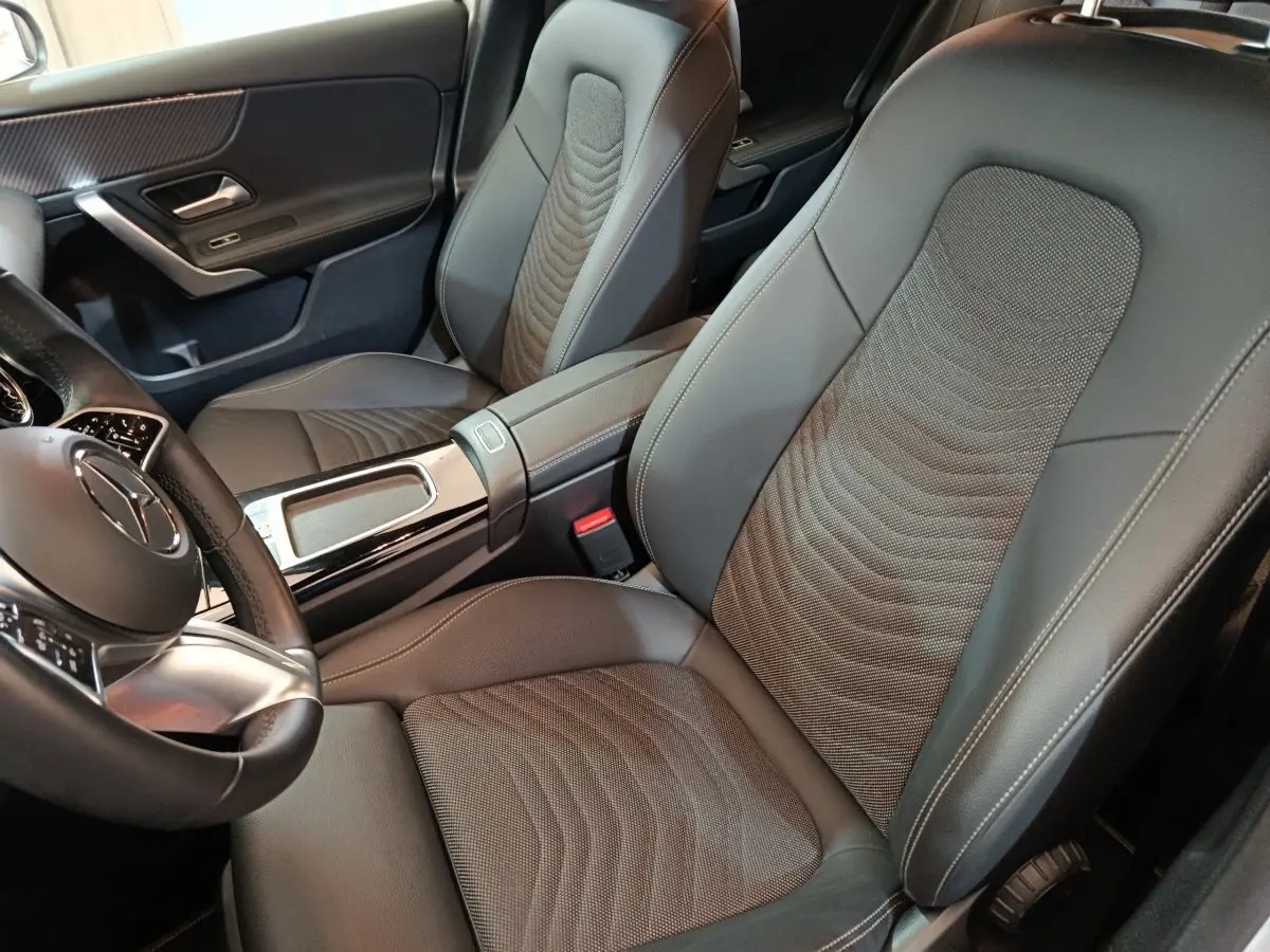 Vue intérieure rapprochée des sièges avant gris foncé et volant cuir alu de la Mercedes Classe A 250 e Business Line 2023.