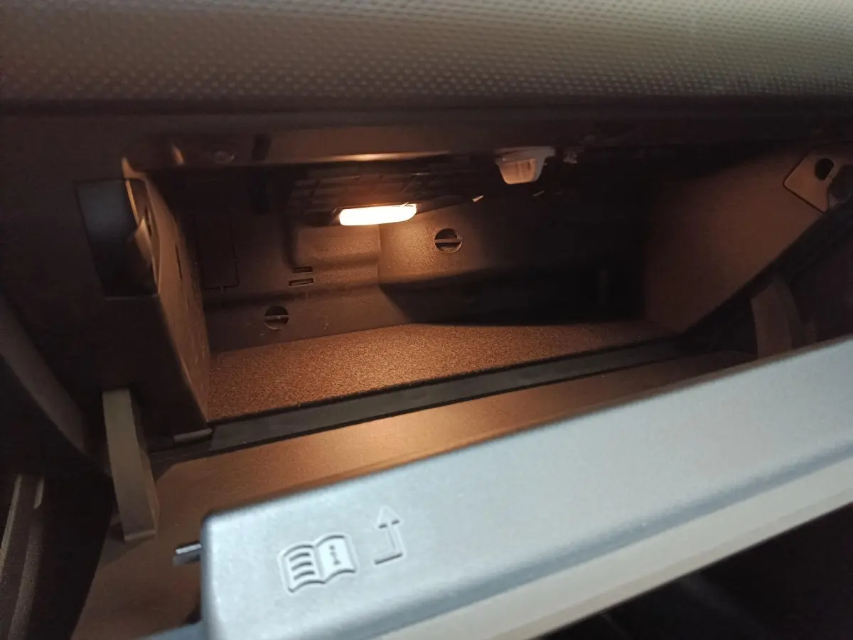 Intérieur de la boîte à gants éclairée de la Mercedes Classe A 250 e Business Line gris clair, vue rapprochée.