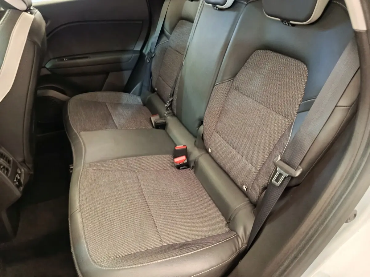 Vue intérieure sur la banquette arrière grise du Renault Captur Intens E-TECH Plug-in 2021 avec ceintures visibles.