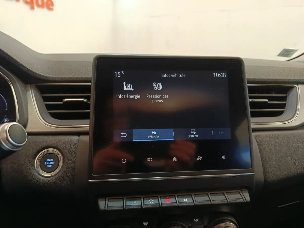 Écran tactile central affichant les infos véhicule et bouton démarrage sur tableau de bord noir du Renault Captur gris clair.