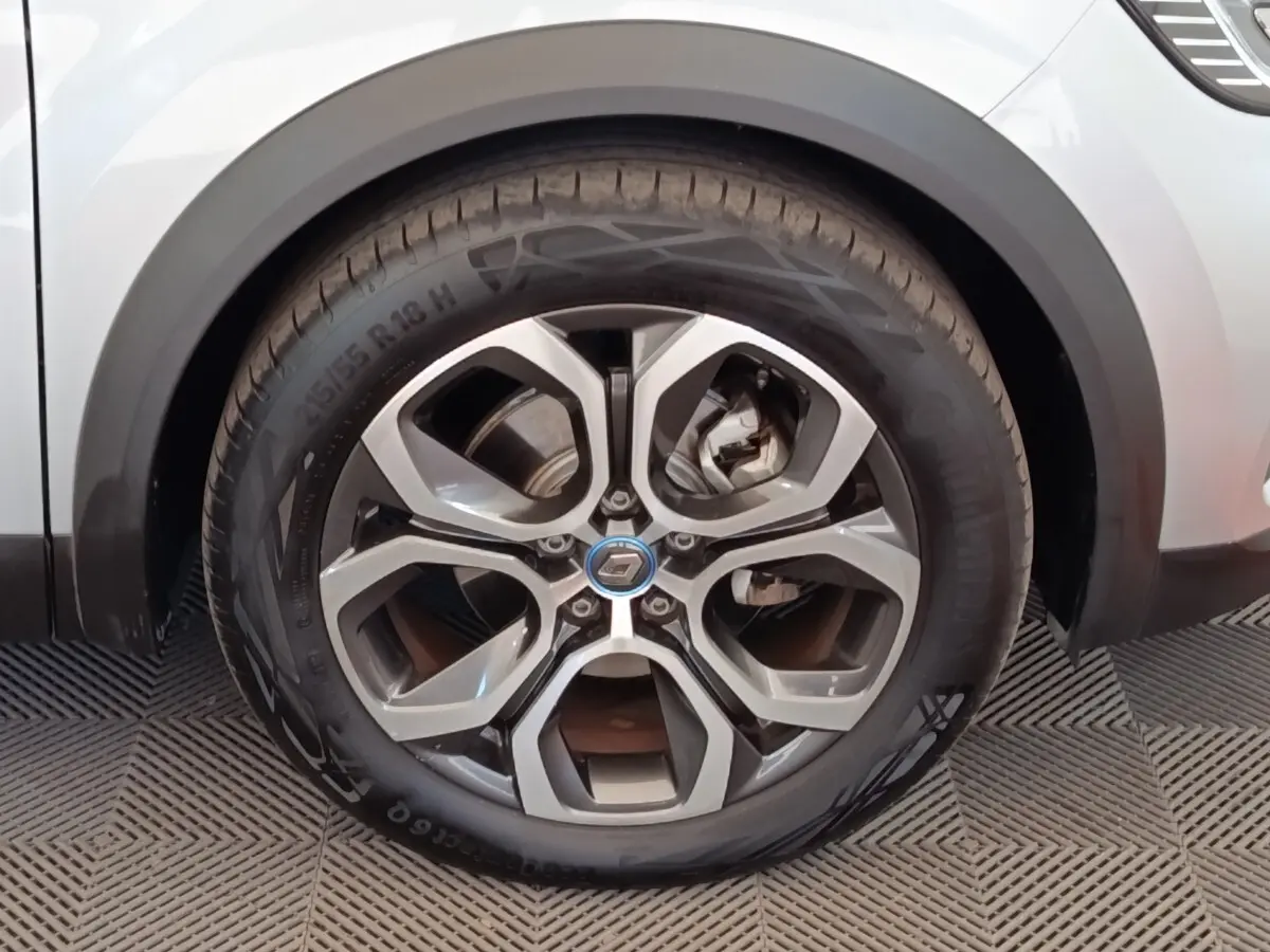 Gros plan sur la roue avant droite du Renault Captur gris clair, mettant en valeur la jante alliage au design moderne.