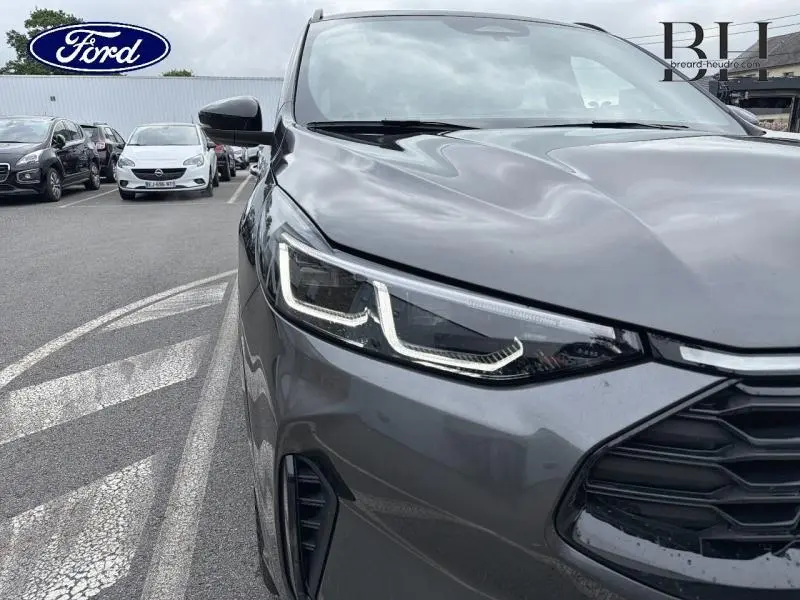 Gros plan sur l'avant droit du Ford Kuga gris Magnetic avec projecteurs Dynamic Matrix LED et calandre noire.