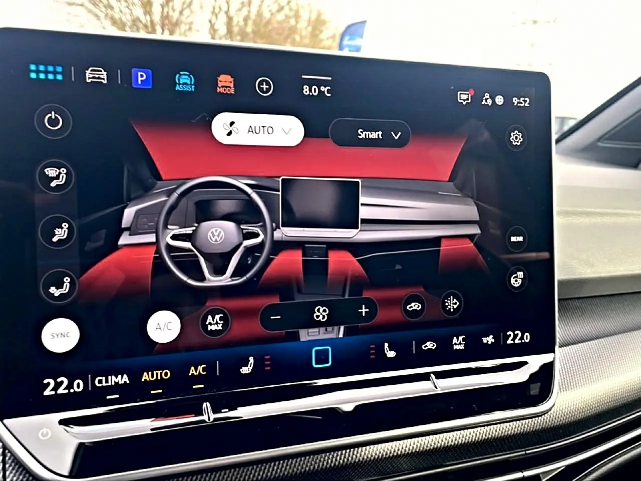Écran tactile intérieur de la Volkswagen Golf 2026 montrant le tableau de bord avec ambiance rouge et commandes climatisation.