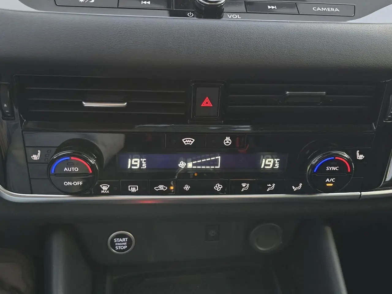 Tableau de bord du Nissan Qashqai 2024 avec climatisation automatique bi-zone et bouton start/stop en vue frontale rapprochée.