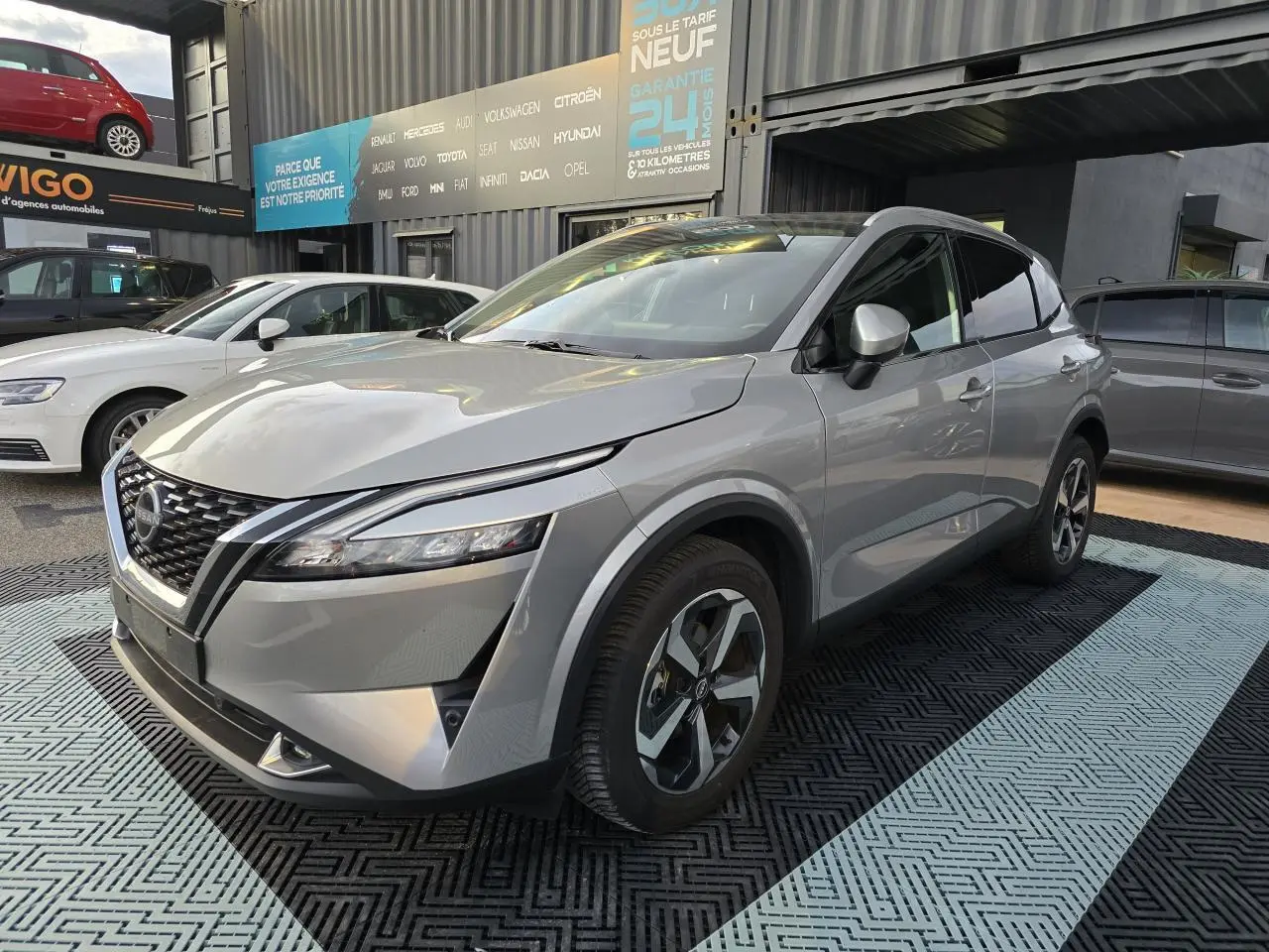 Nissan Qashqai III gris silver en 3/4 avant droit, avec jantes alliage 18 pouces et calandre V-Motion distinctive.