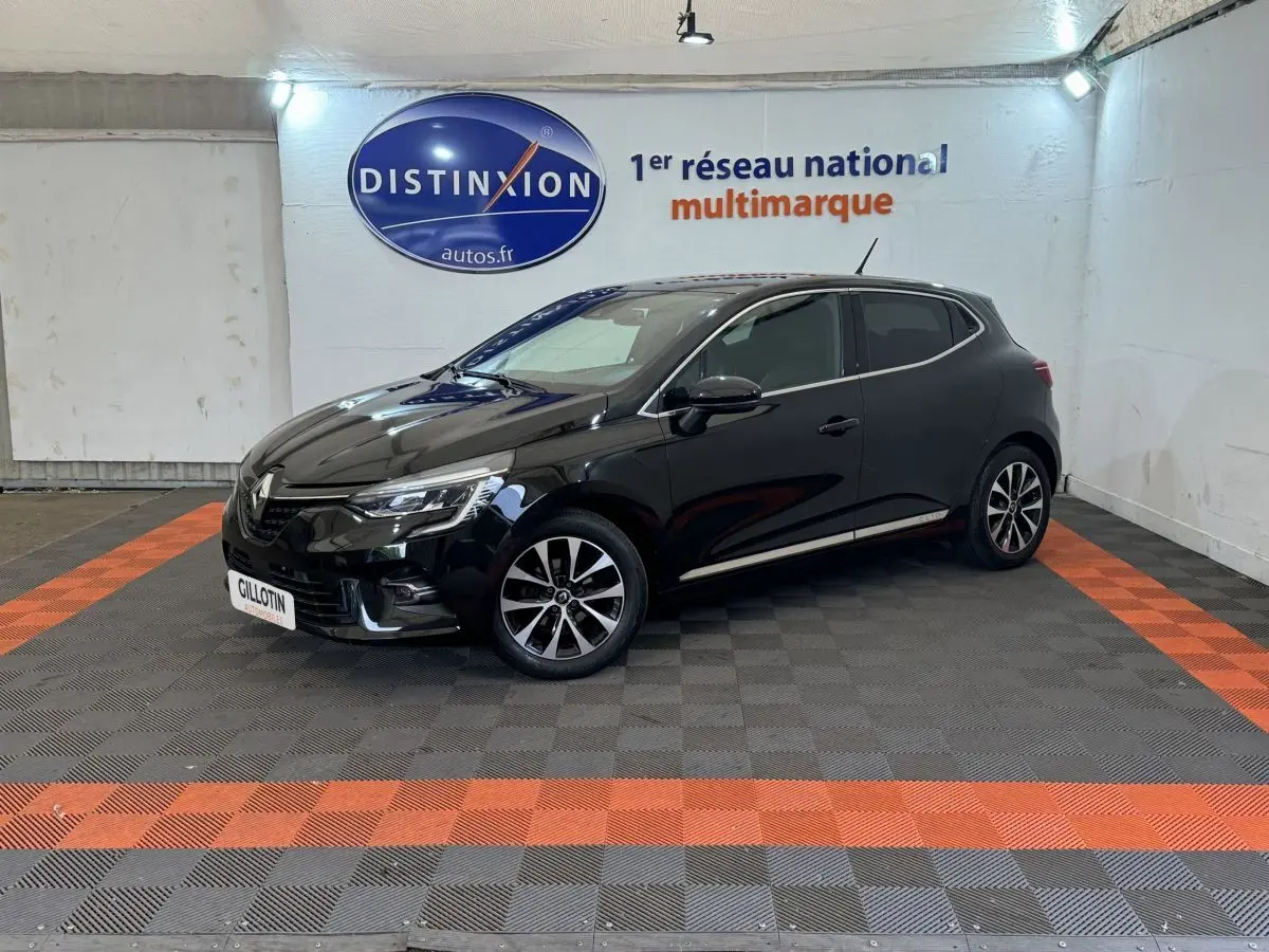 Renault Clio Intens TCe 100 noire vue de profil côté gauche dans un showroom avec sol gris et bandes orange.