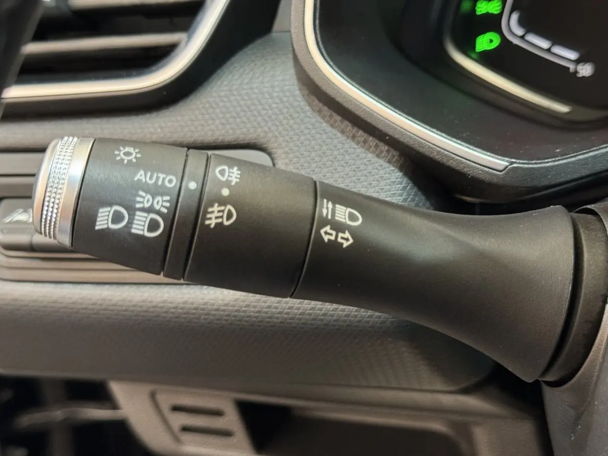 Gros plan sur la commande des phares et clignotants dans l'habitacle noir de la Renault Clio Intens TCe 100 2020.