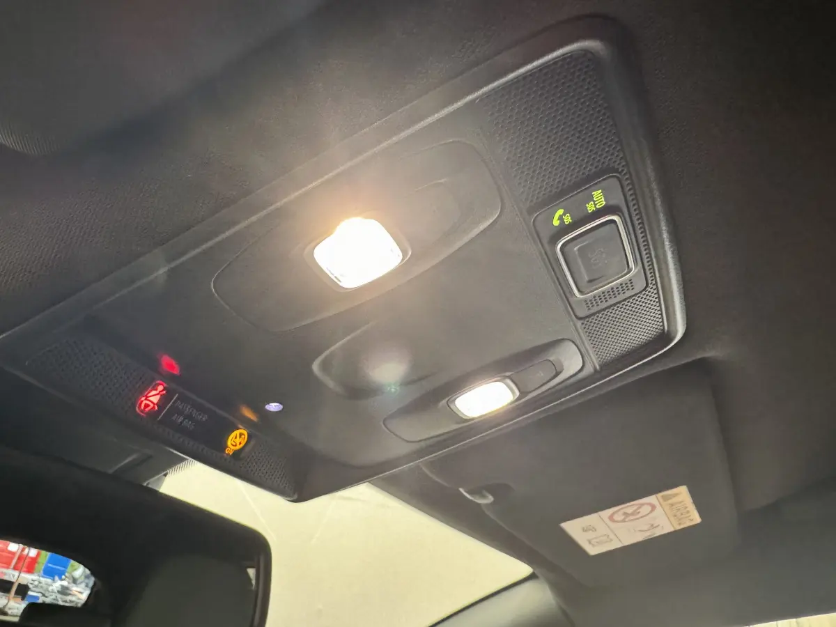 Plafonnier intérieur allumé avec commandes et avertissements sur toit noir d'une Renault Clio Intens TCe 100 2020.