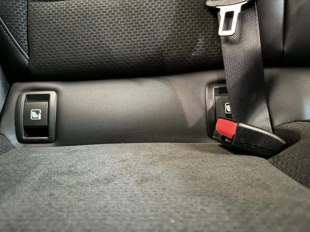 Gros plan sur la banquette arrière noire de la Renault Clio Intens avec ceintures et fixations Isofix visibles.