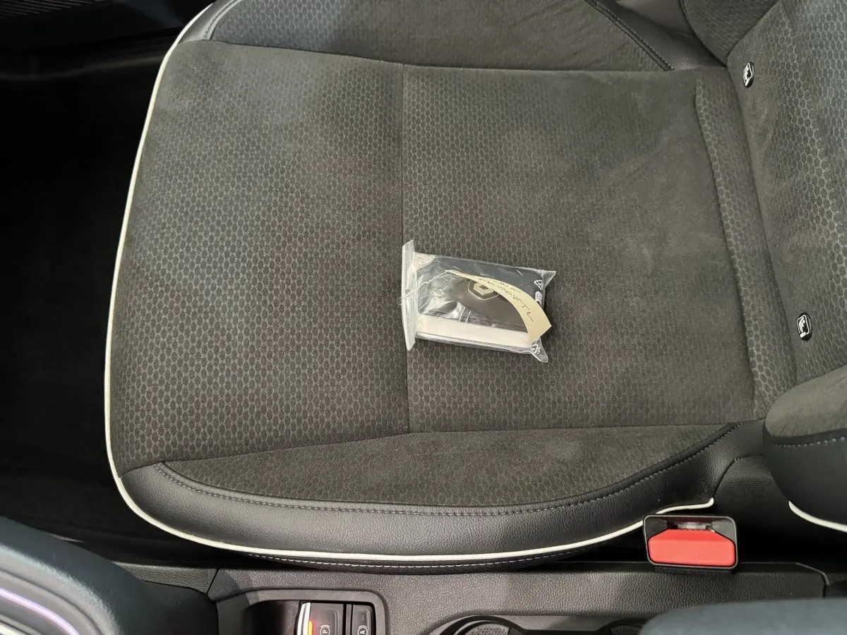 Gros plan sur le siège avant droit noir de la Renault Clio Intens 2020 avec clé dans un sachet plastique posé dessus.