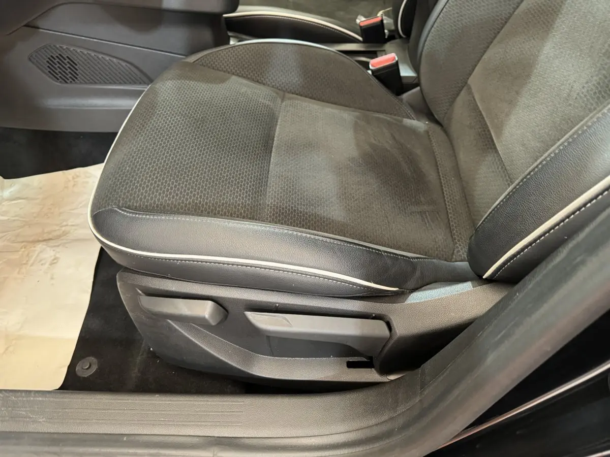 Gros plan sur le siège avant droit noir avec surpiqûres blanches de la Renault Clio Intens TCe 100 2020.