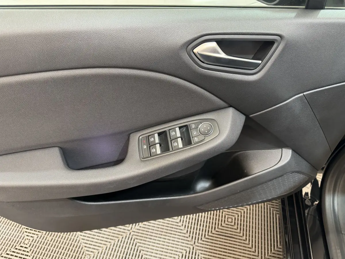 Vue rapprochée de la porte avant gauche noire de la Renault Clio Intens 2020 avec commandes électriques des vitres et rétroviseurs.