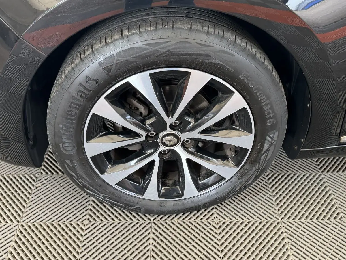 Gros plan sur la roue avant droite noire d'une Renault Clio Intens TCe 100 avec jante alliage bicolore.