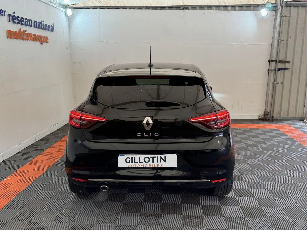 Vue arrière d'une Renault Clio Intens TCe 100 noire, avec feux LED et sortie d'échappement visible à gauche.