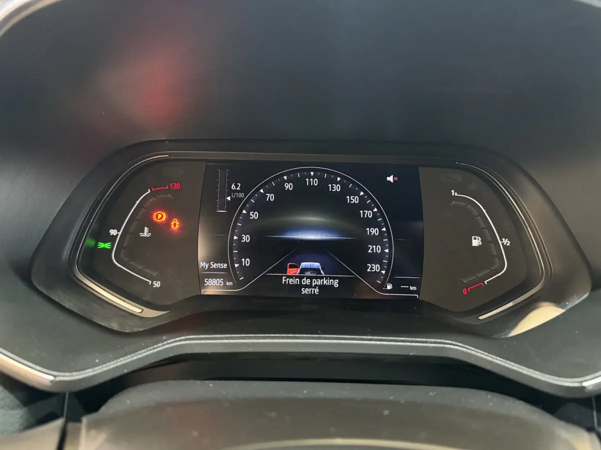 Tableau de bord numérique de Renault Clio Intens TCe 100 noir, affichant le compteur et alertes au frein de parking serré.