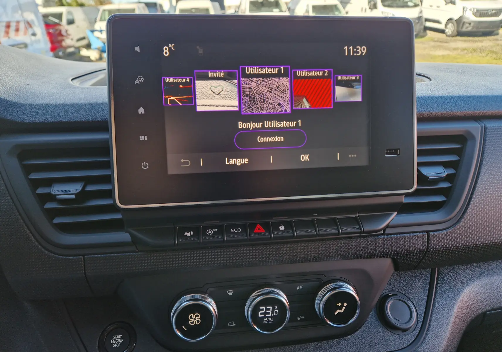 Vue rapprochée de l’écran tactile 8 pouces et de la console centrale du Renault Trafic Fourgon blanc, avec commandes climatisation et boutons fonctionnels.