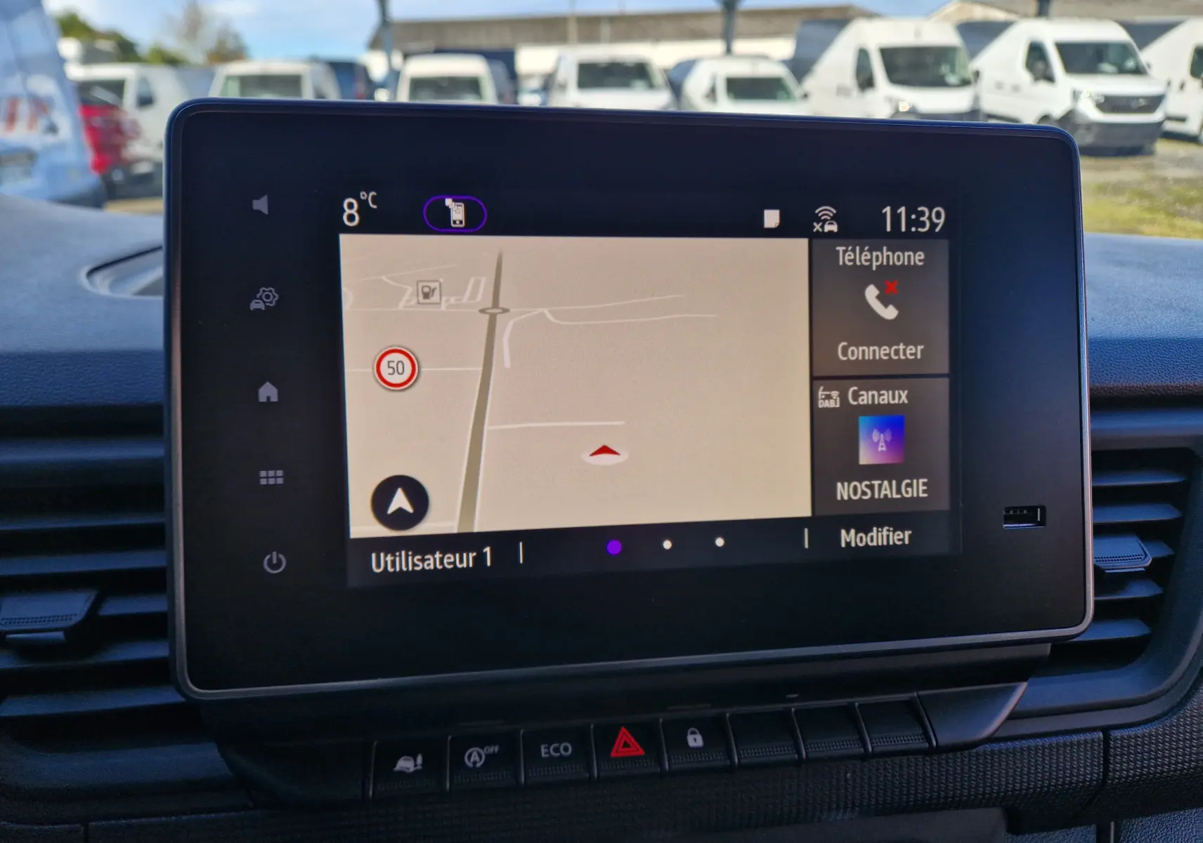 Vue intérieure centrée sur l'écran tactile Easy Link 8'' du Renault Trafic blanc, affichant la navigation et options connectées.