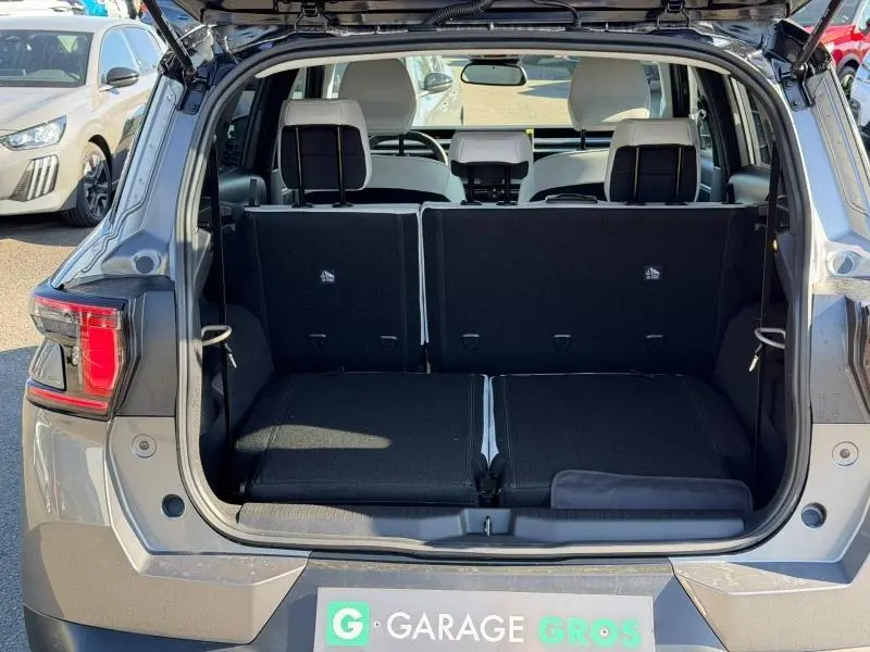 Coffre ouvert vu de l'arrière d'un Citroën C3 Aircross gris Mercury avec sièges arrière partiellement rabattus.
