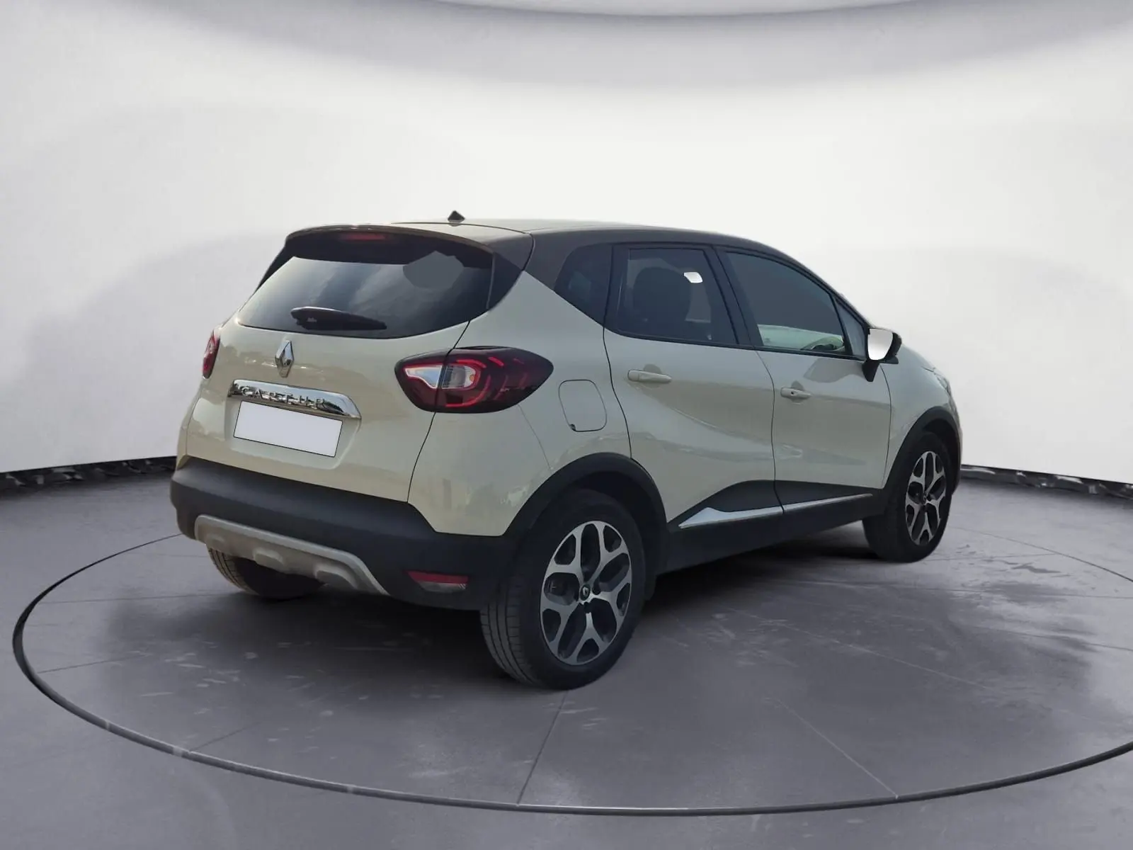 Vue 3/4 arrière droite d'un Renault Captur beige/marron 2018 avec toit noir et jantes alliage noires.