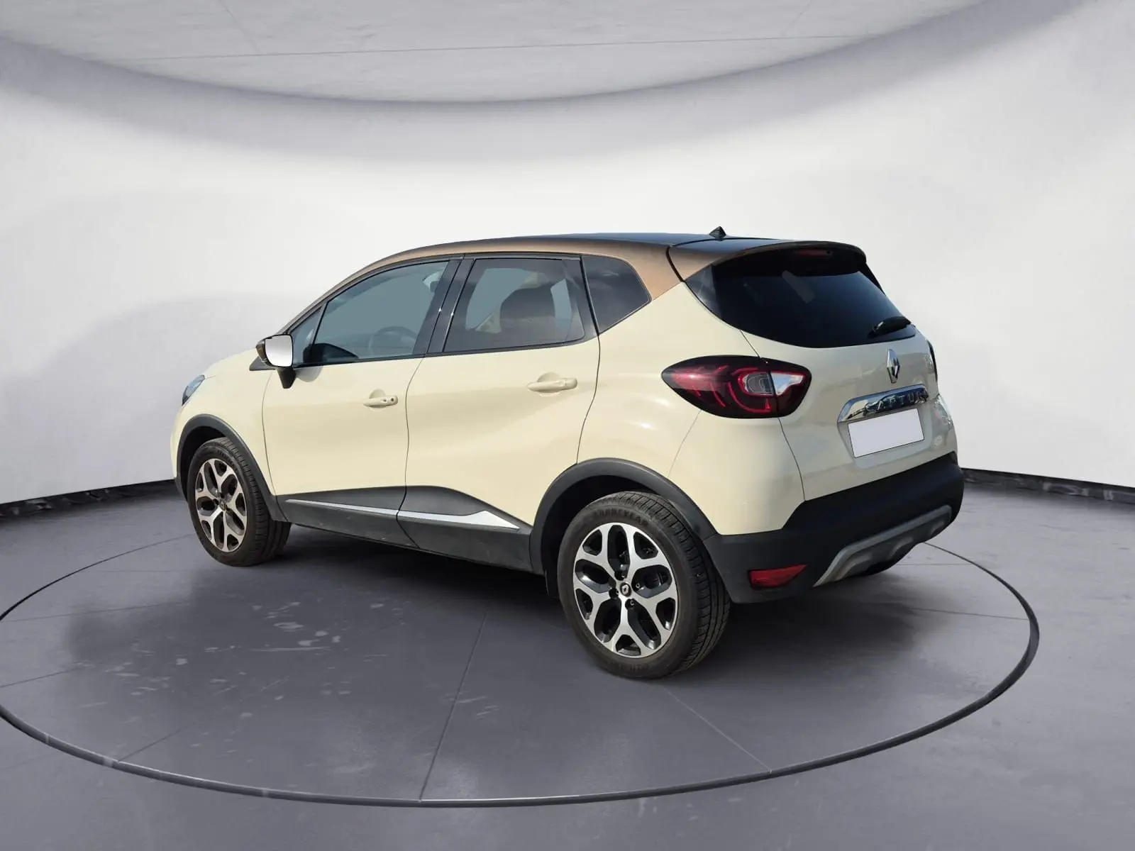 Renault Captur beige et marron en vue 3/4 arrière droit, avec jantes alliage et toit foncé contrastant.