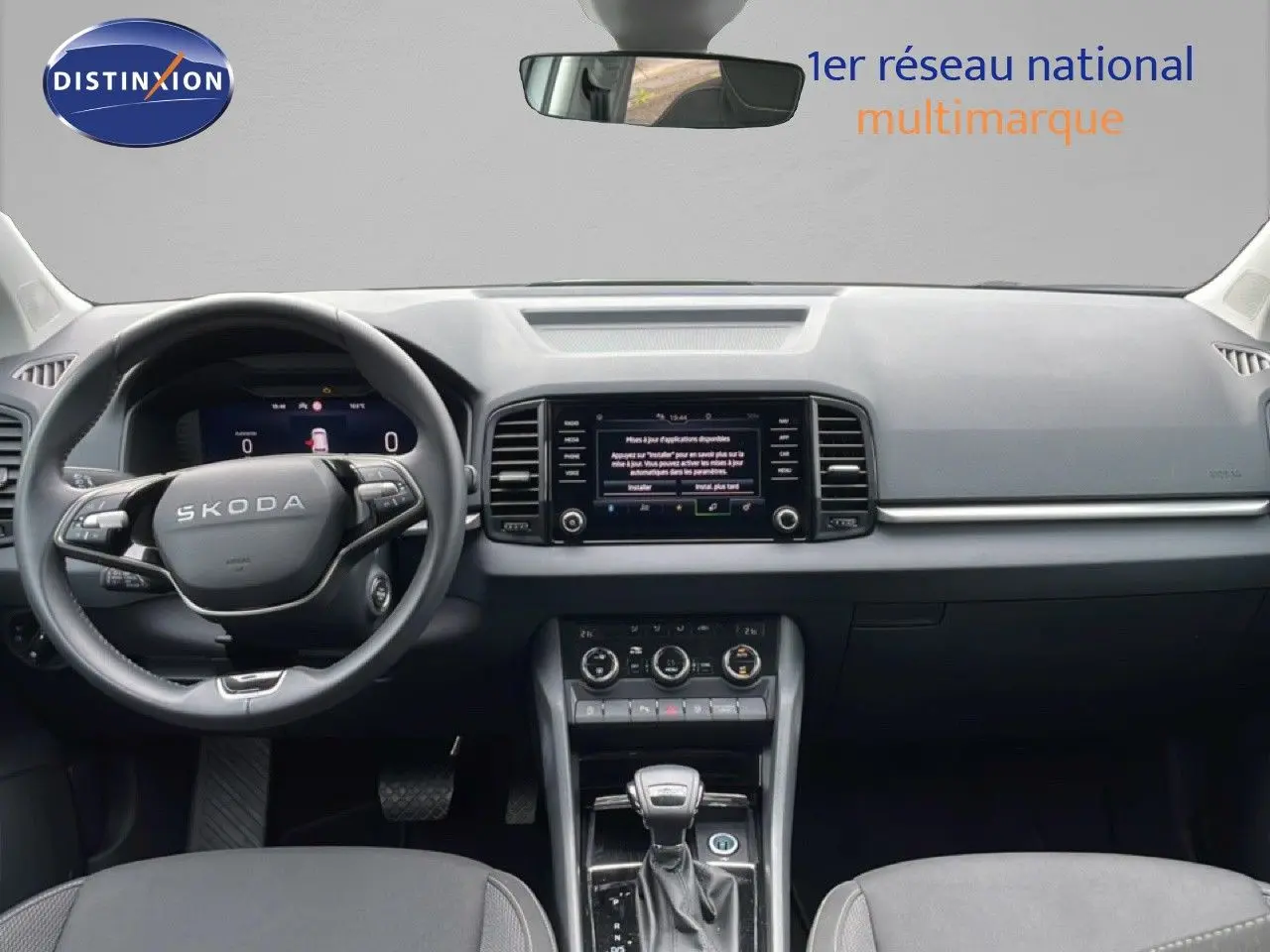 Vue intérieure frontale du Skoda Karoq blanc glacier 2025, avec tableau de bord moderne et écran tactile central.