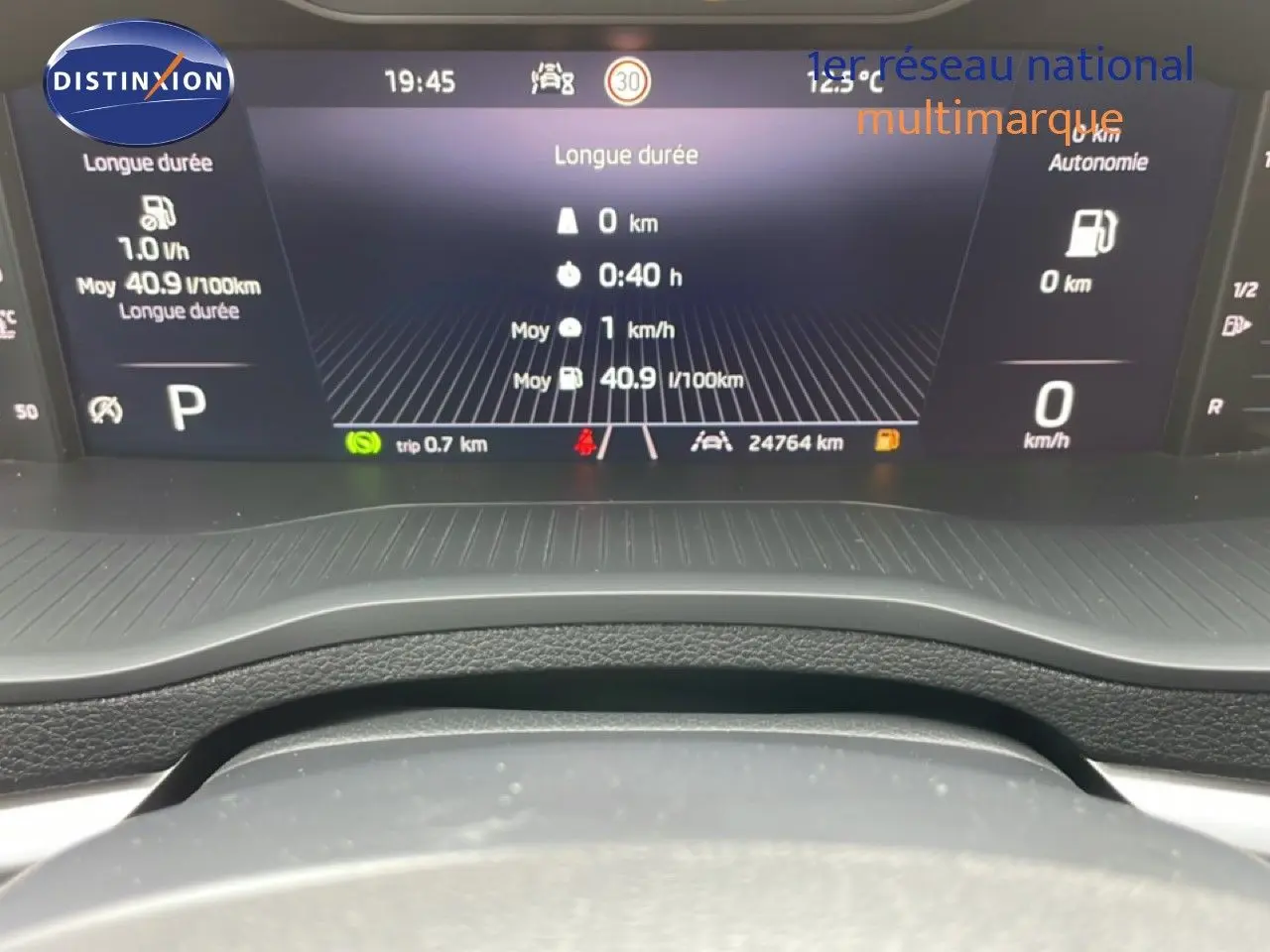 Tableau de bord numérique du Skoda Karoq blanc glacier, affichant les données de conduite en vue frontale.
