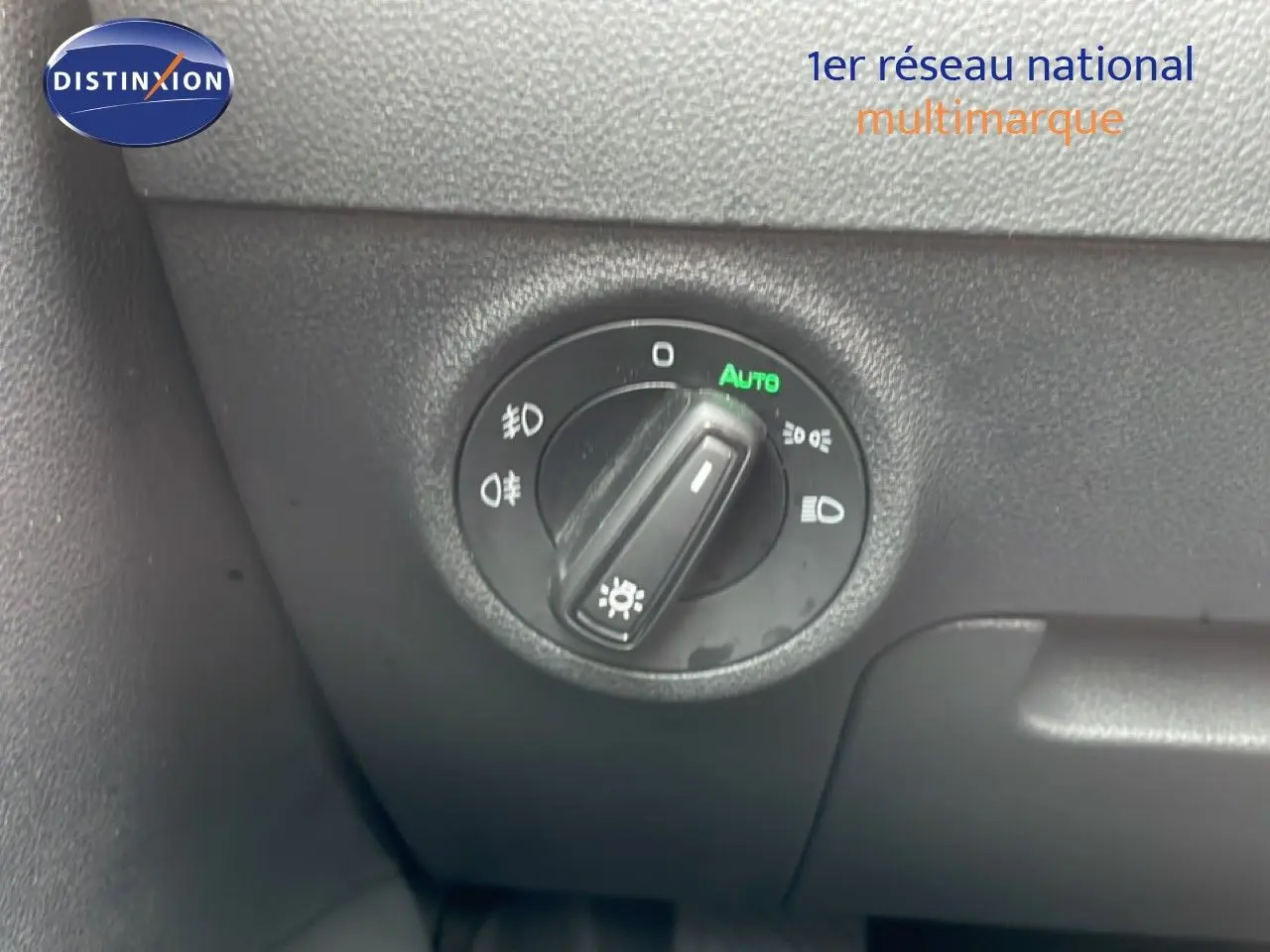 Gros plan sur le bouton de commande des phares du Skoda Karoq blanc glacier, intérieur côté gauche.