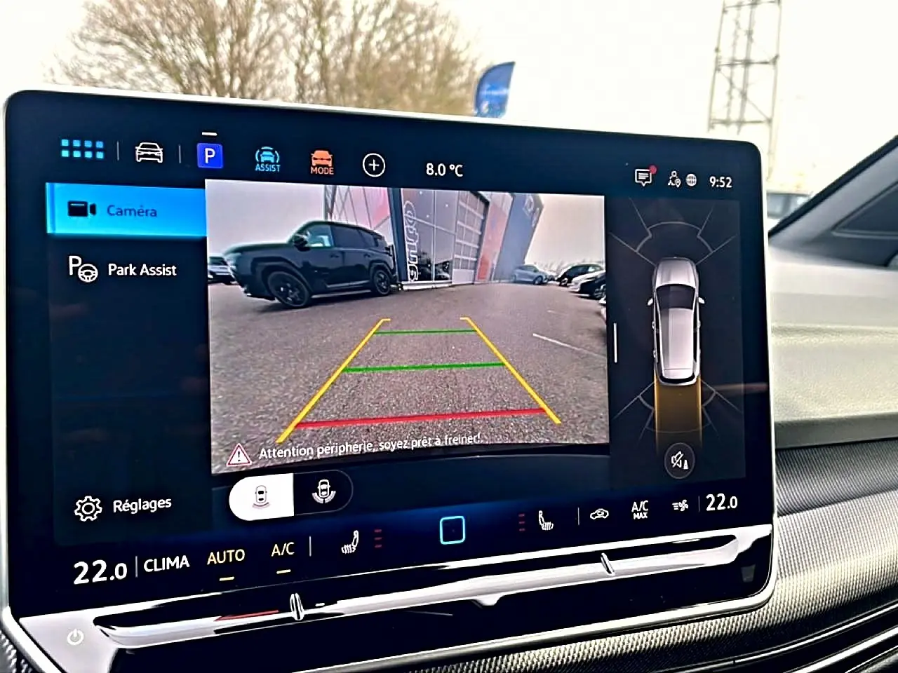 Écran de caméra de recul affichant un SUV noir vu de côté gauche dans un parking, interface Volkswagen Golf 2026.