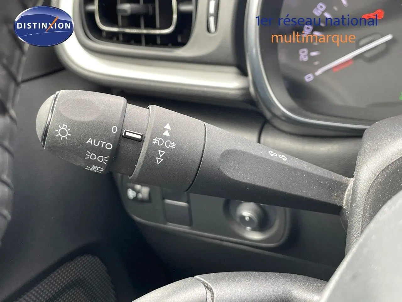Gros plan sur la manette de phares et clignotants dans l'habitacle d'une Citroën C3 gris Artense 2021.