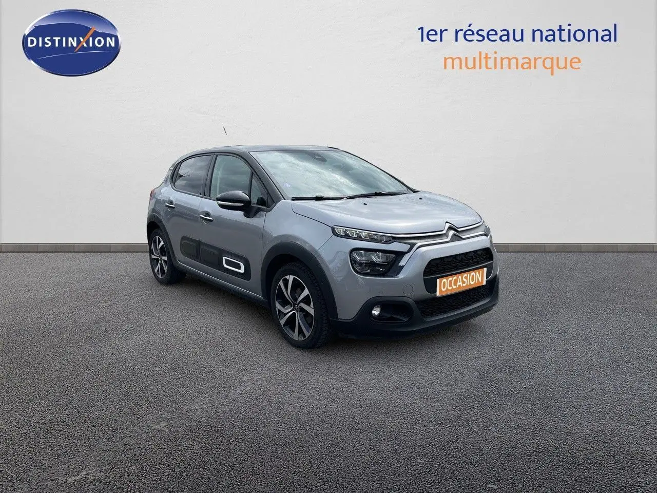 Citroën C3 gris Artense métal vue 3/4 avant droit avec ses protections latérales blanches distinctives.