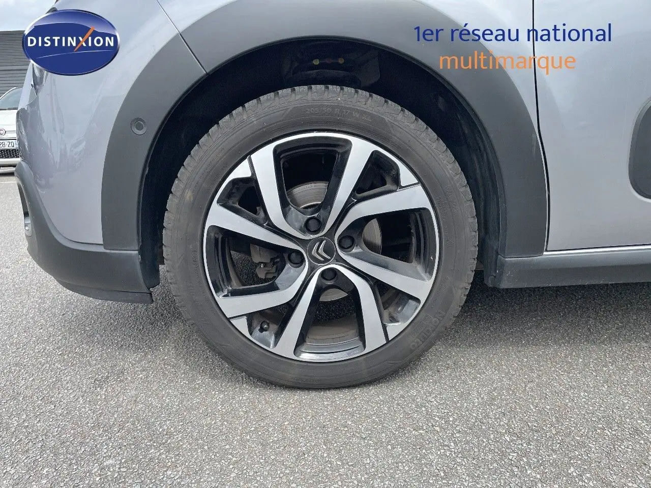 Gros plan sur la roue avant gauche de la Citroën C3 gris Artense métal avec jante alliage bicolore distinctive.