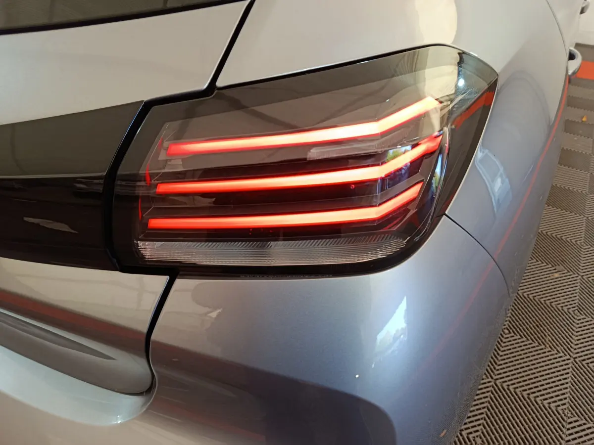Gros plan sur le feu arrière droit rouge d'une Peugeot 208 PureTech 100 S&S Allure gris clair 2025