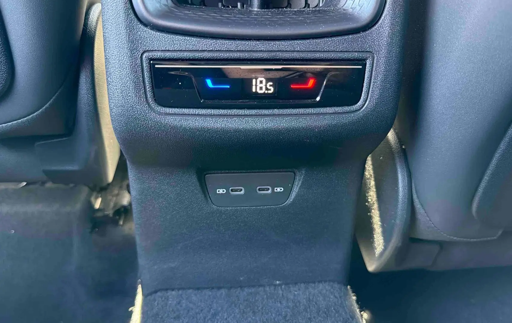 Détail de la console arrière avec commandes climatisation et deux ports USB-C du CUPRA Terramar gris 2025.
